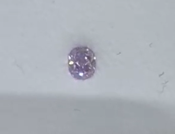 Purple gemstone on a light gray background