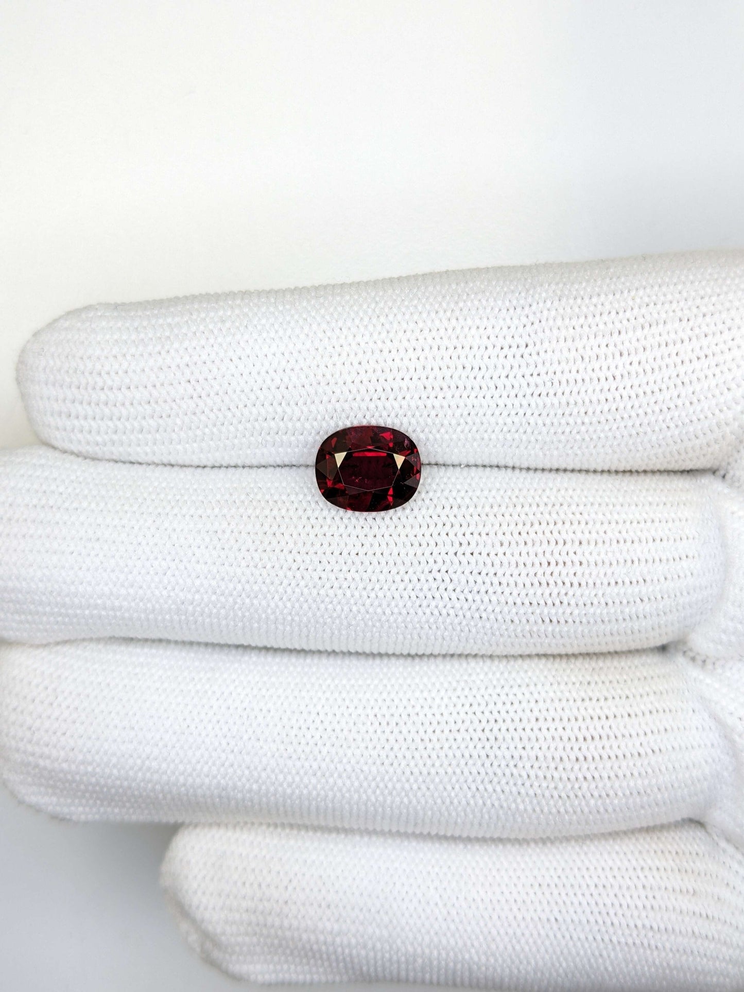 Red gemstone on a white textured surface