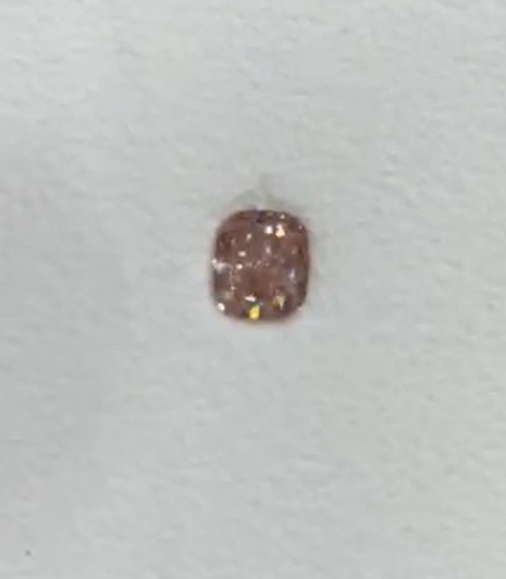 Fancy Intense Pink gemstone on a light gray background