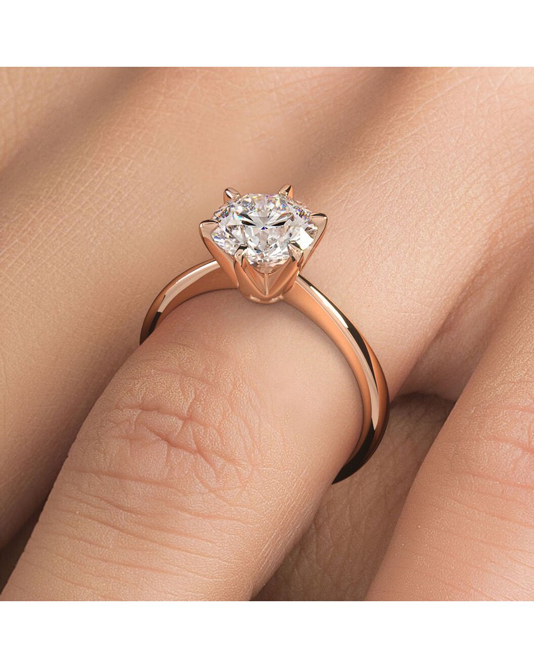 Rose gold diamond ring on a finger against a neutral background