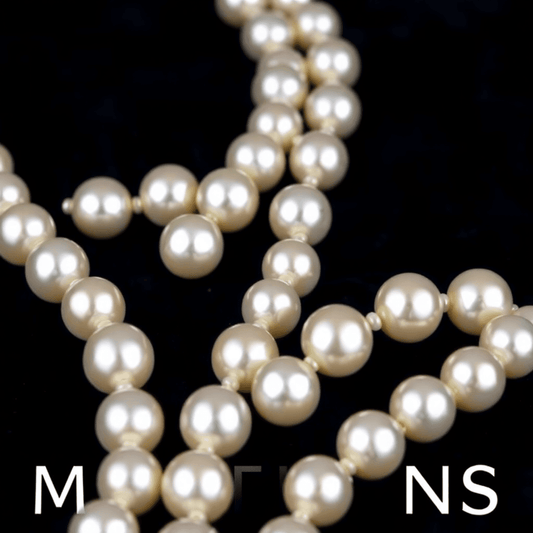 Close-up of a lustrous white pearl necklace elegantly arranged on dark velvet, symbolizing timeless elegance and milestone celebrations.