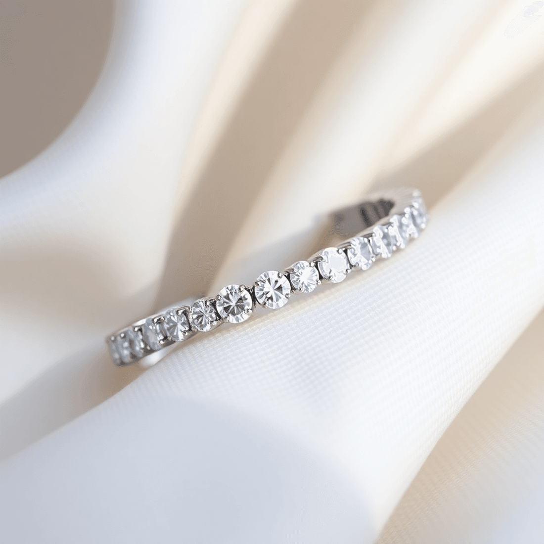 Close-up of a sparkling lab-grown diamond tennis bracelet on soft neutral fabric, highlighted by gentle natural light showcasing its brilliance and elegance.