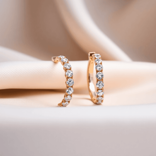 Close-up of sparkling diamond hoop earrings on soft fabric, highlighted by gentle lighting showcasing their brilliance and craftsmanship.