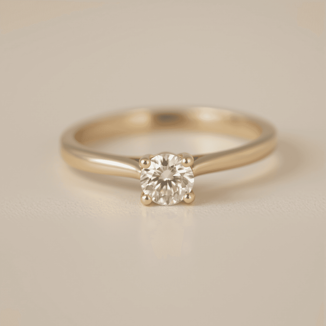 Close-up of a sparkling solitaire diamond ring on a simple band against a soft, neutral background, highlighting its timeless elegance.