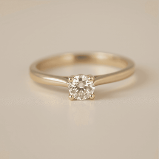 Close-up of a sparkling solitaire diamond ring on a simple band against a soft, neutral background, highlighting its timeless elegance.