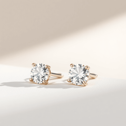 Close-up of sparkling diamond stud earrings on a neutral background, highlighting their elegance and timeless beauty in soft natural light.