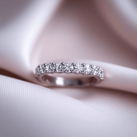 Close-up of a diamond eternity band ring on soft fabric, with sparkling light reflections highlighting the continuous circle of diamonds.