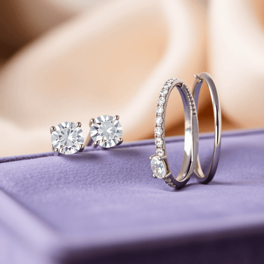 Close-up of sparkling diamond stud and hoop earrings on a velvet tray with a soft, luxurious background.