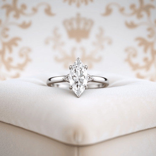 Close-up of a sparkling marquise cut diamond ring in white gold on a soft velvet cushion with subtle royal motifs in the background.