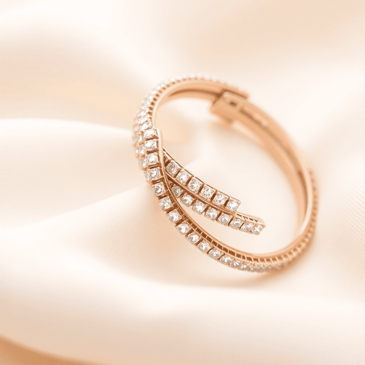 Close-up of elegant diamond bangles with single and multiple rows of sparkling diamonds on soft neutral fabric, highlighting luxury and shimmer.