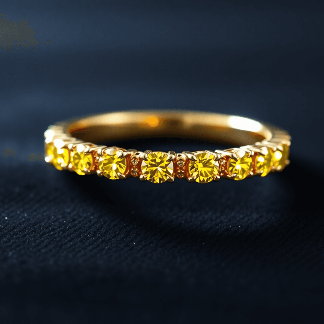 Close-up of a gold eternity band with vibrant yellow diamonds glowing softly on a dark velvet background, showcasing elegance and luxury.