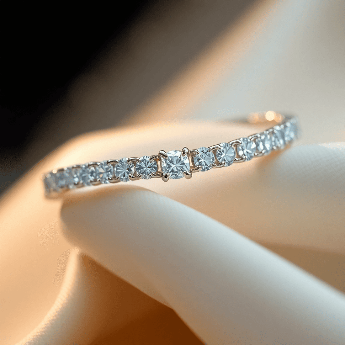Close-up of a sparkling lab-grown diamond tennis bracelet on soft fabric with glowing light effects, highlighting brilliance and luxury craftsmanship.