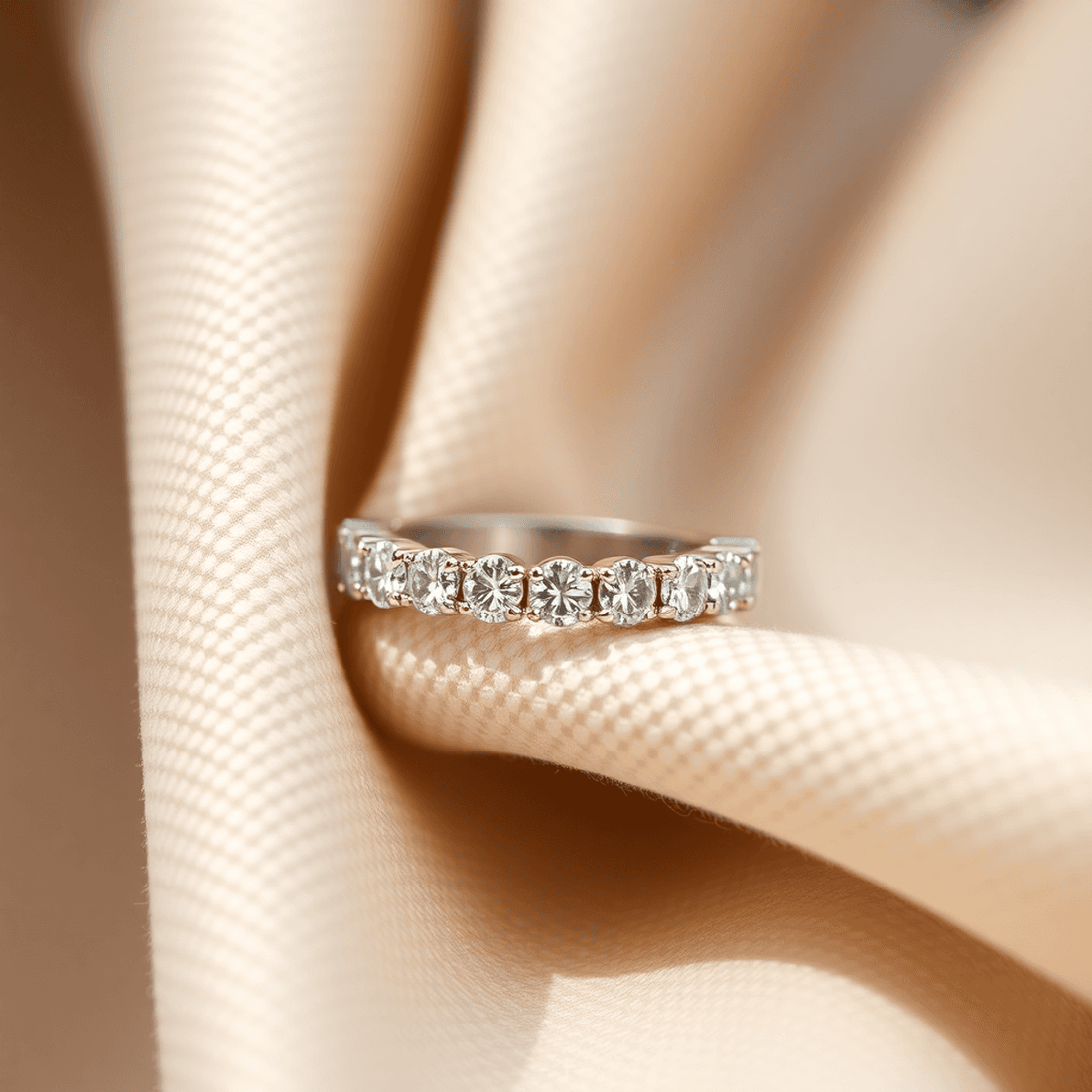 Close-up of a sparkling diamond eternity band on soft neutral fabric, illuminated by natural light showcasing its brilliance and clarity.