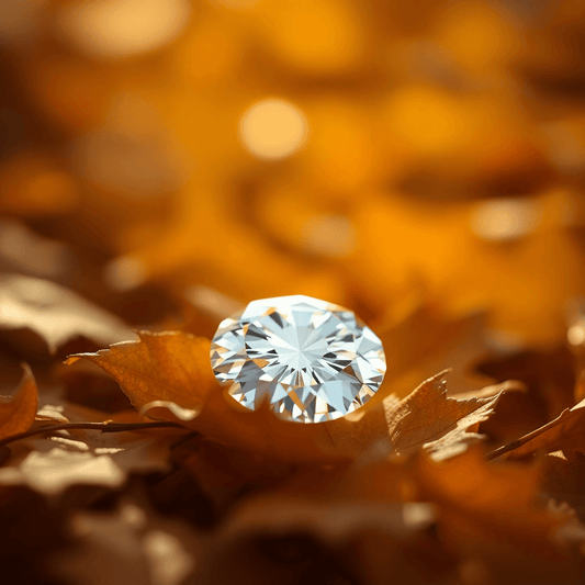 Close-up of a sparkling diamond on golden autumn leaves with a softly blurred background, highlighting its clarity and elegance.