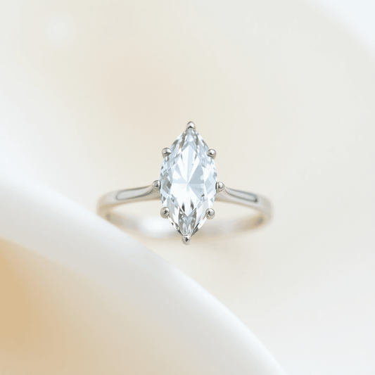 Close-up of a sparkling marquise-cut diamond ring with a minimalist design on a soft, elegant background highlighting its timeless and delicate beauty.