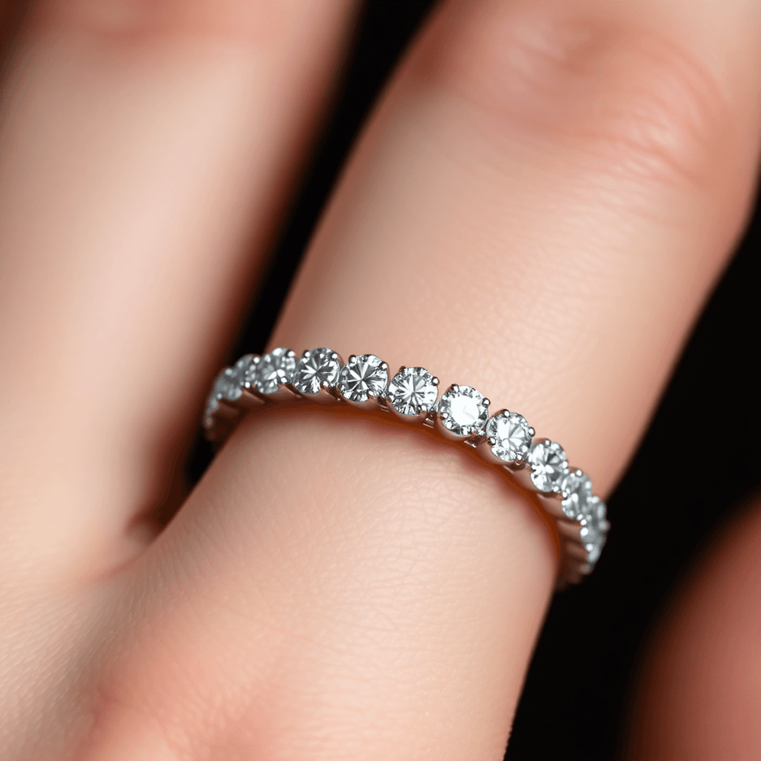 Close-up of a sparkling diamond eternity band on a finger, highlighting the continuous circle of diamonds with soft, elegant lighting.