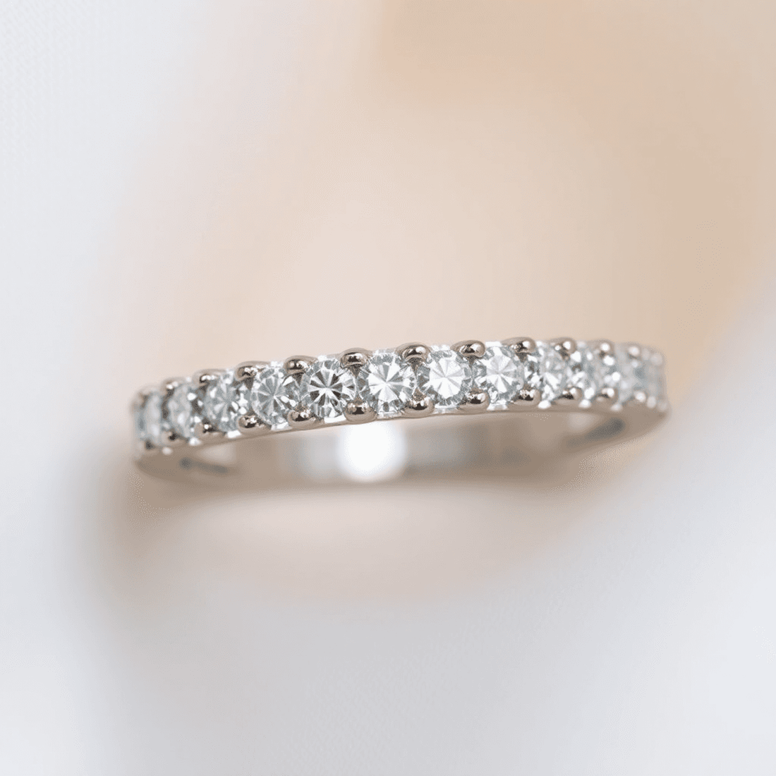 Close-up of a sparkling diamond eternity ring with continuous diamonds on a soft, elegant background highlighting its brilliance.