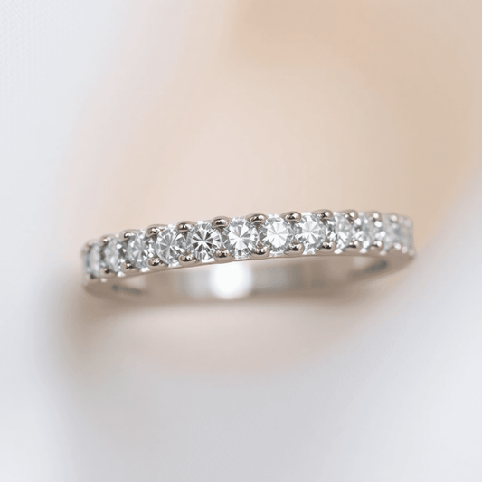 Close-up of a sparkling diamond eternity ring with continuous diamonds on a soft, elegant background highlighting its brilliance.
