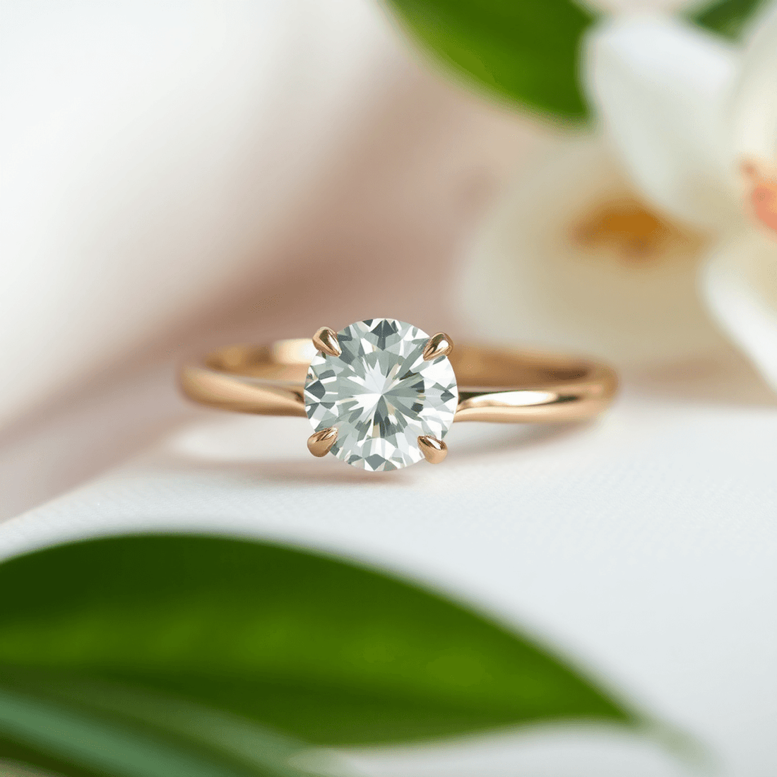Close-up of a sparkling diamond ring on a sleek band, resting on a soft surface with green leaves in the background, symbolizing ethical and sustainable love.