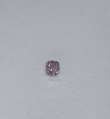 Fancy Intense Purple-Pink diamond on a light gray background