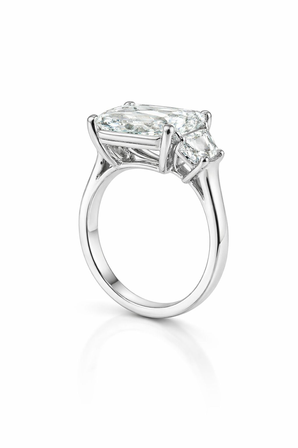 Diamond ring with three clear gemstones on a white background