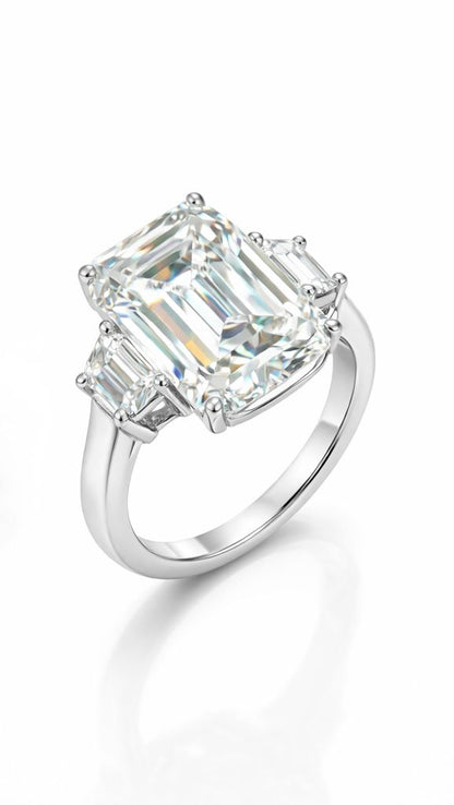 Diamond ring with emerald-cut center stone on a white background