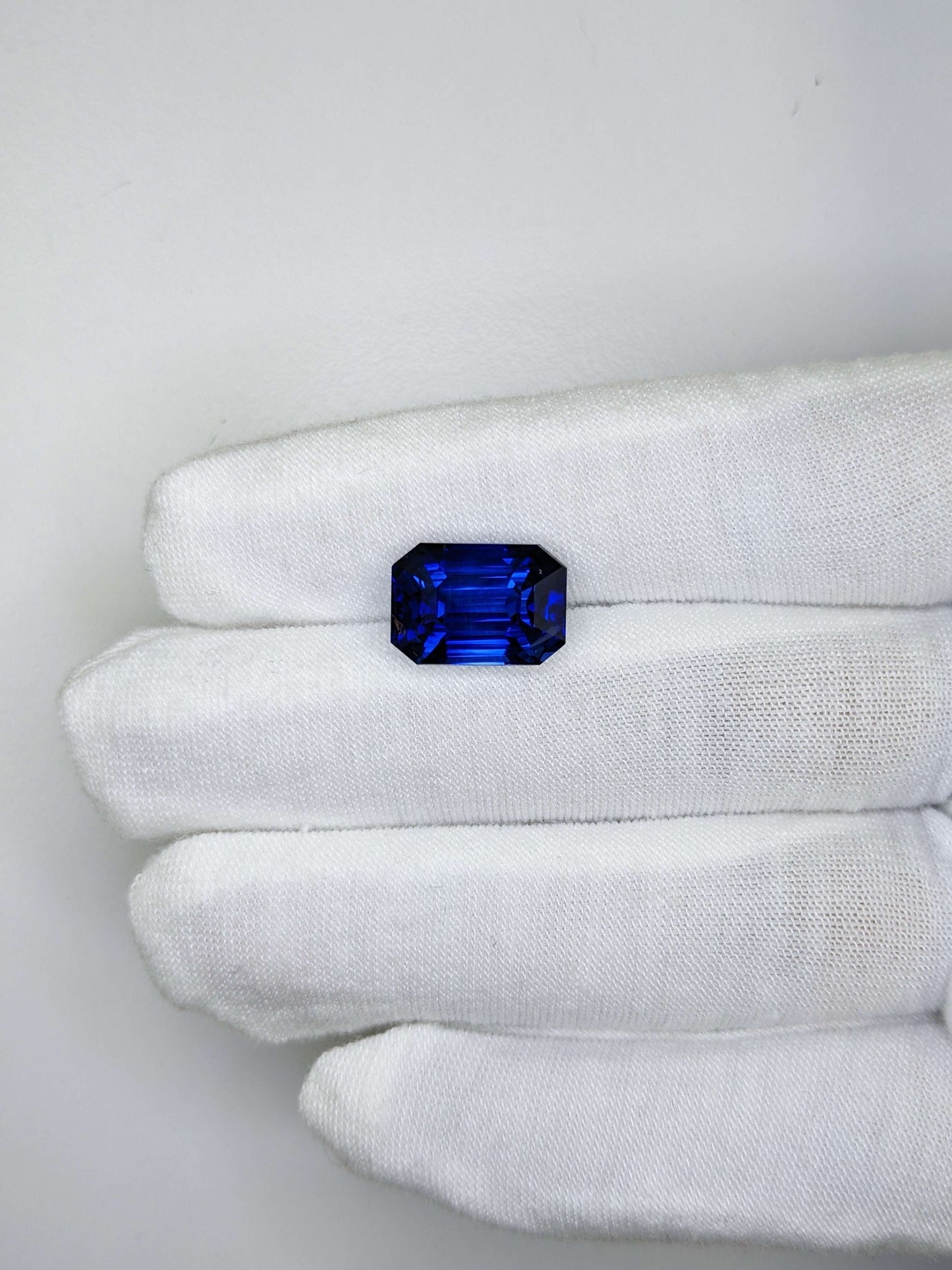 10.94 Carat Emerald Cut Heat Royal Blue Sapphire Loose Gemstone GIA Certified On Gloved Hand