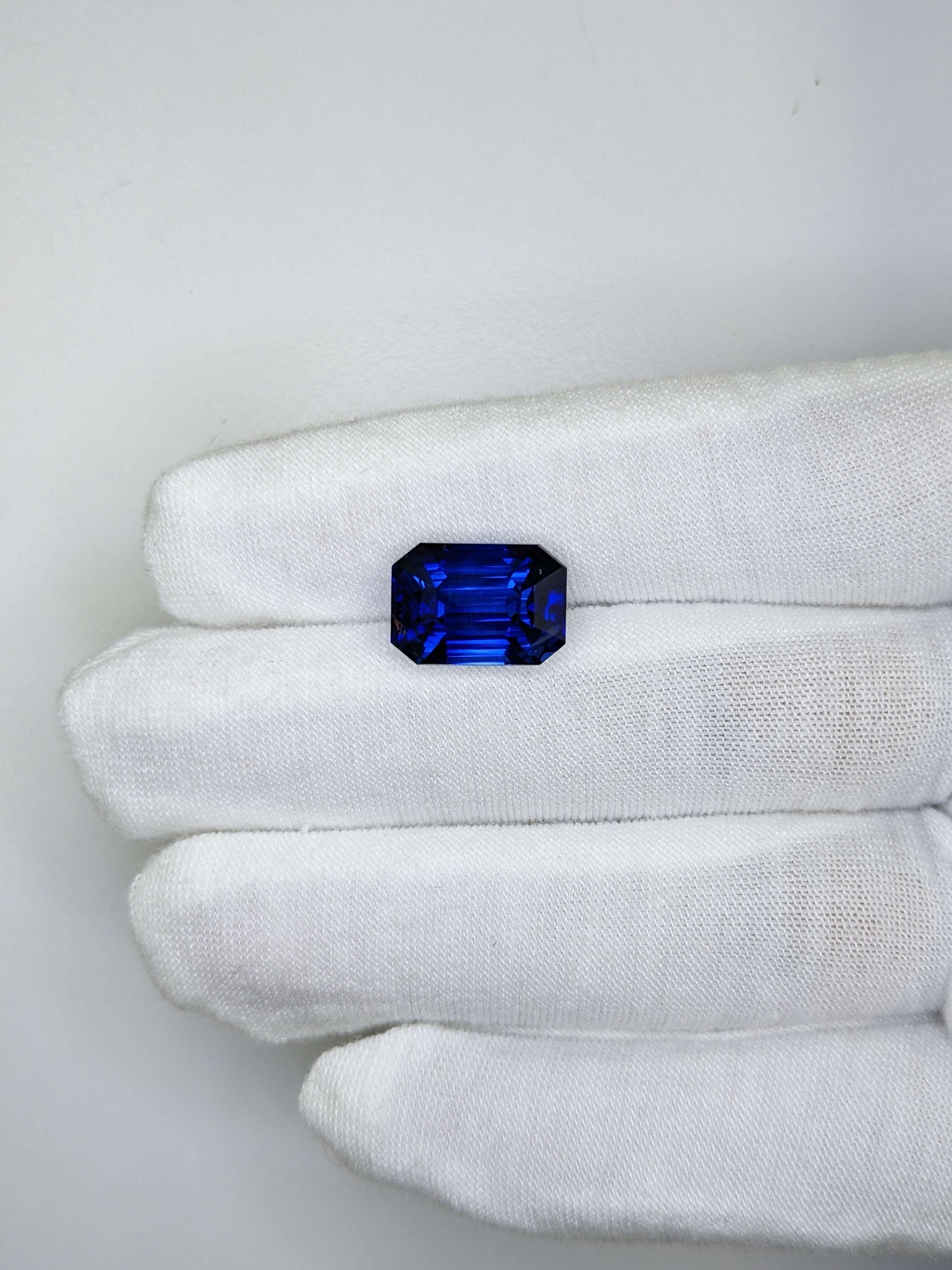 10.94 Carat Emerald Cut Heat Royal Blue Sapphire Loose Gemstone GIA Certified On Gloved Hand