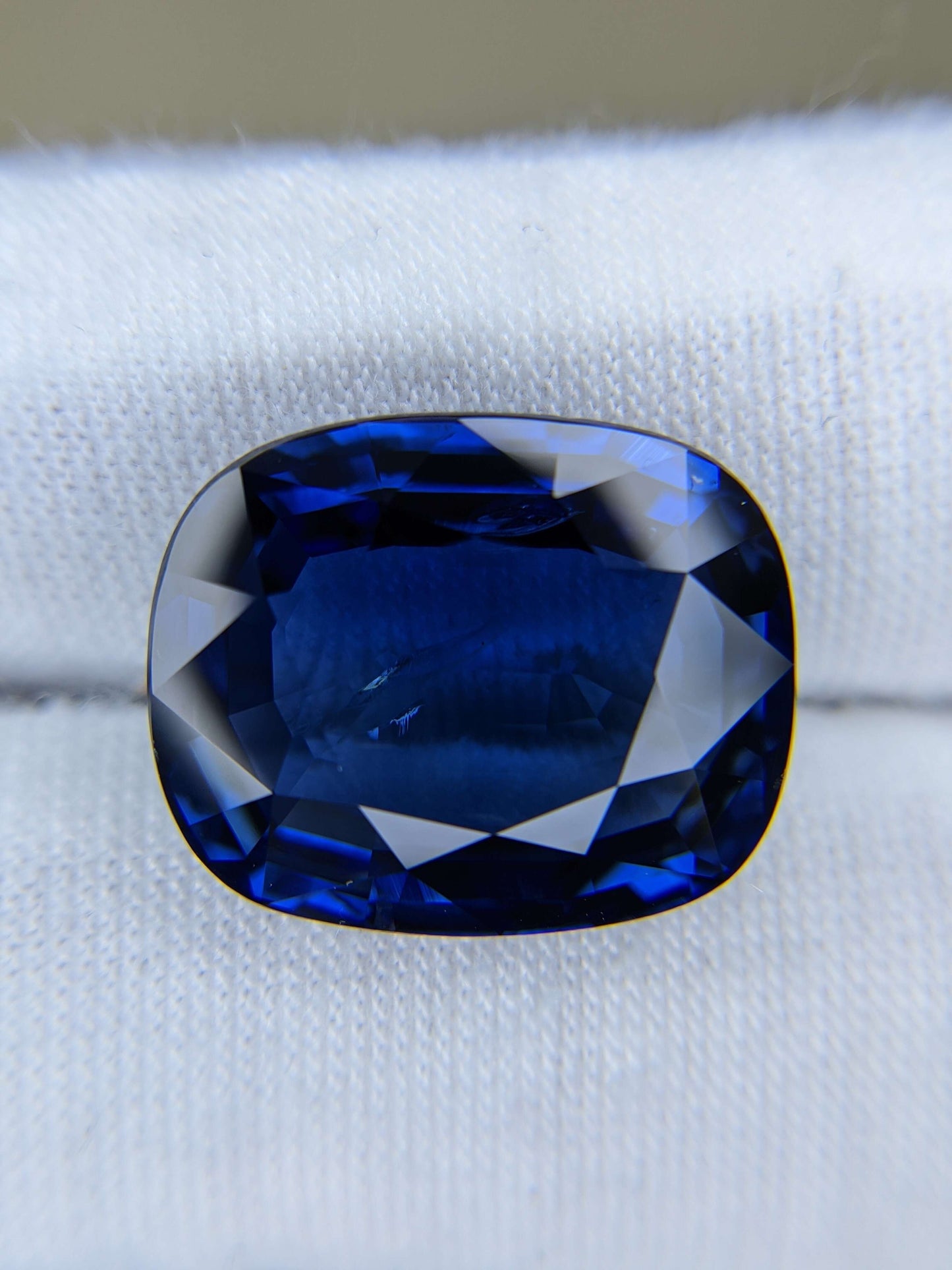 Cushion-shaped blue gemstone on a white background