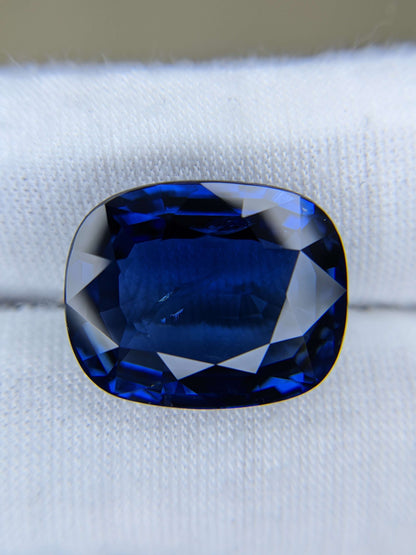 Cushion-shaped blue gemstone on a white background