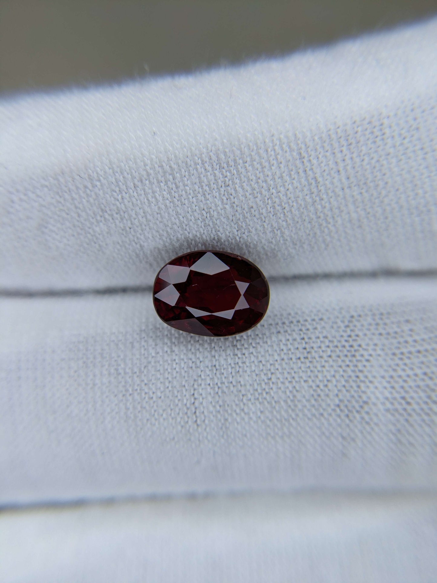 Red ruby gemstone on a white fabric background