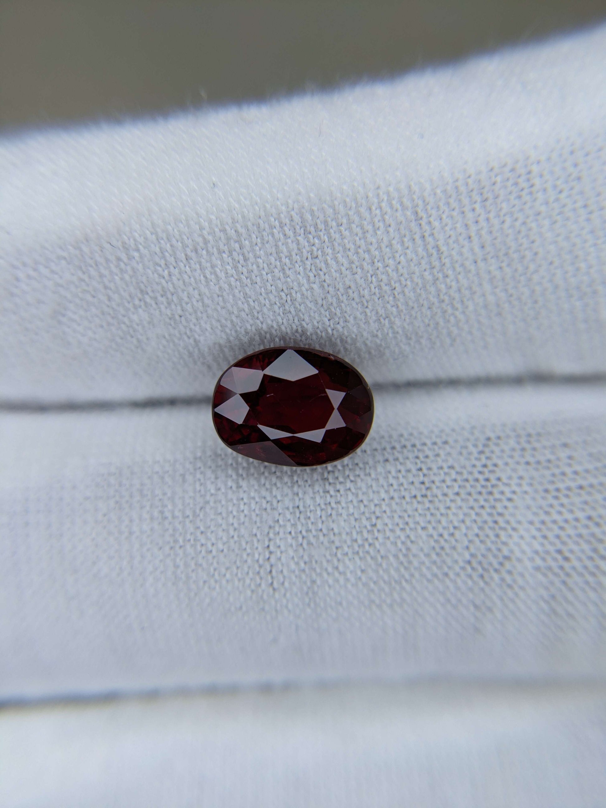 Red ruby gemstone on a white fabric background