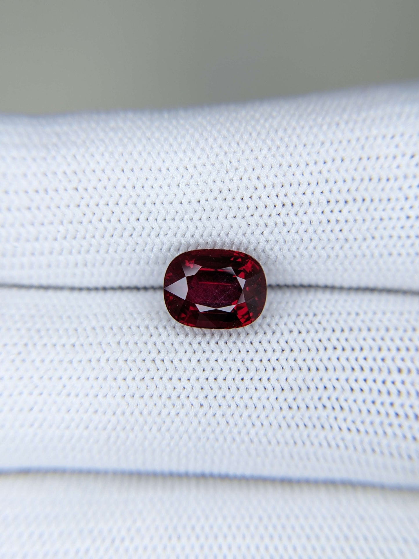 Red ruby gemstone on a white fabric background