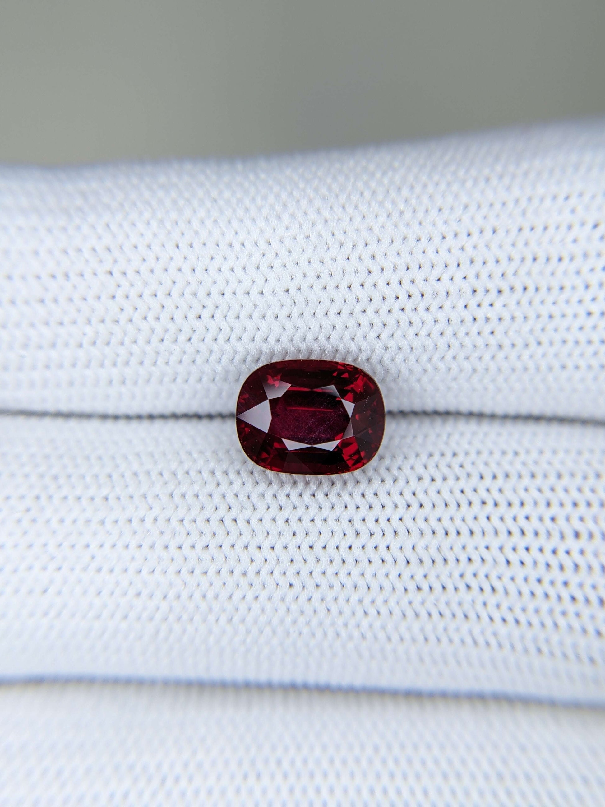 Red ruby gemstone on a white fabric background