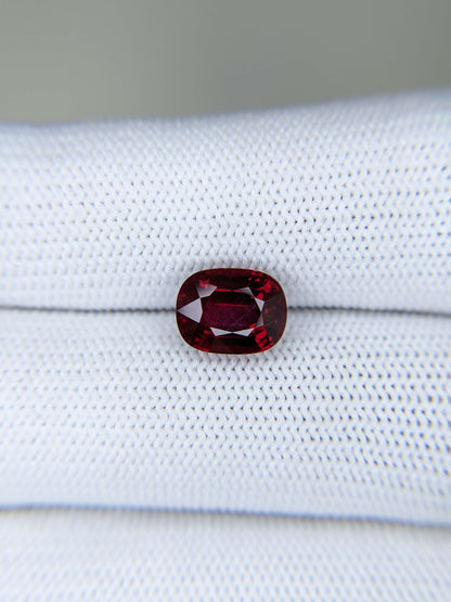 Red ruby gemstone on a white fabric background
