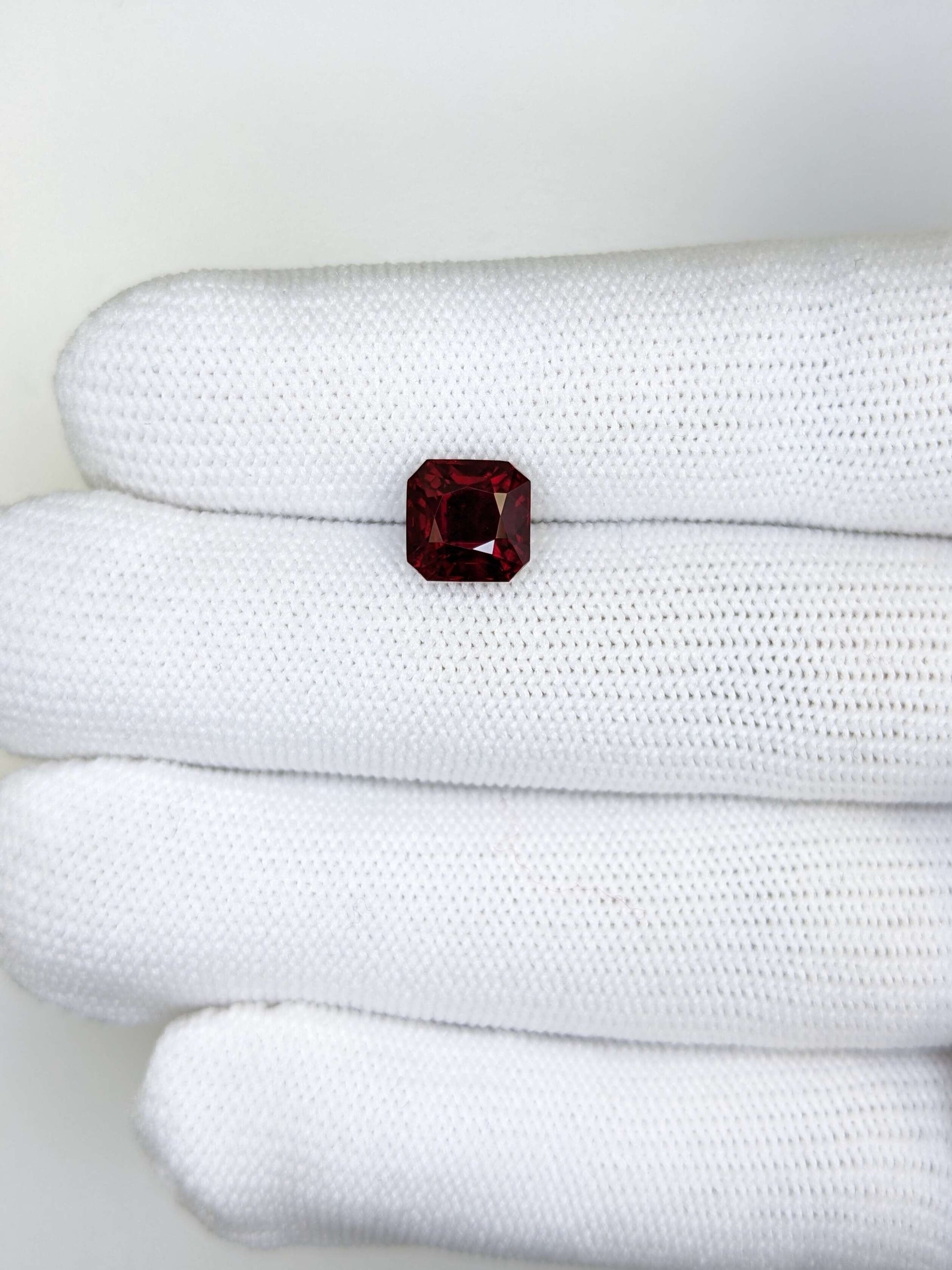 Red gemstone on a white textured surface