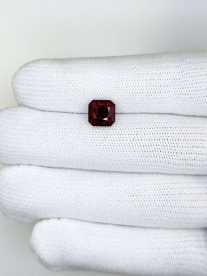 Red gemstone on a white textured surface
