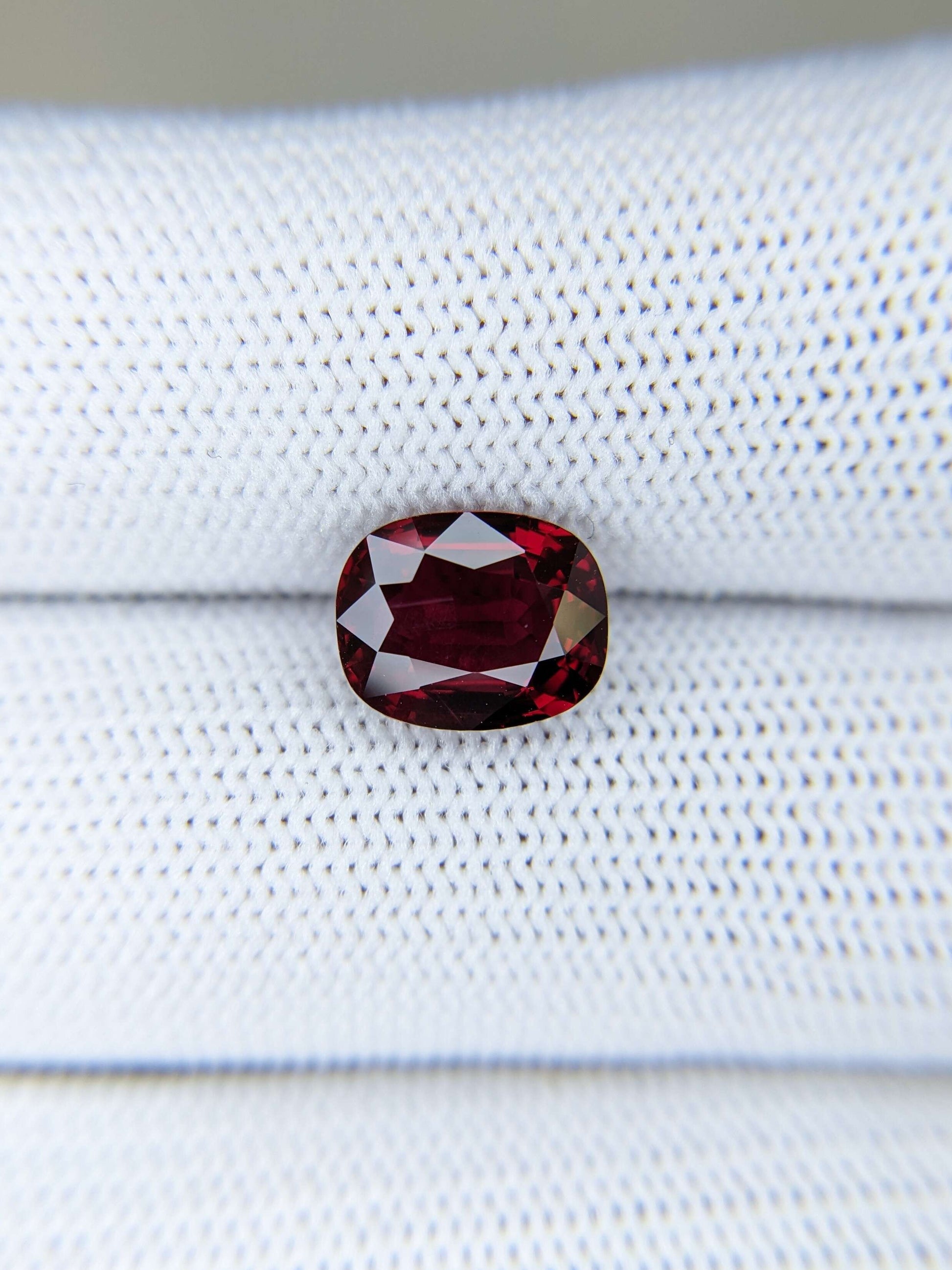 Red ruby gemstone on a white fabric background