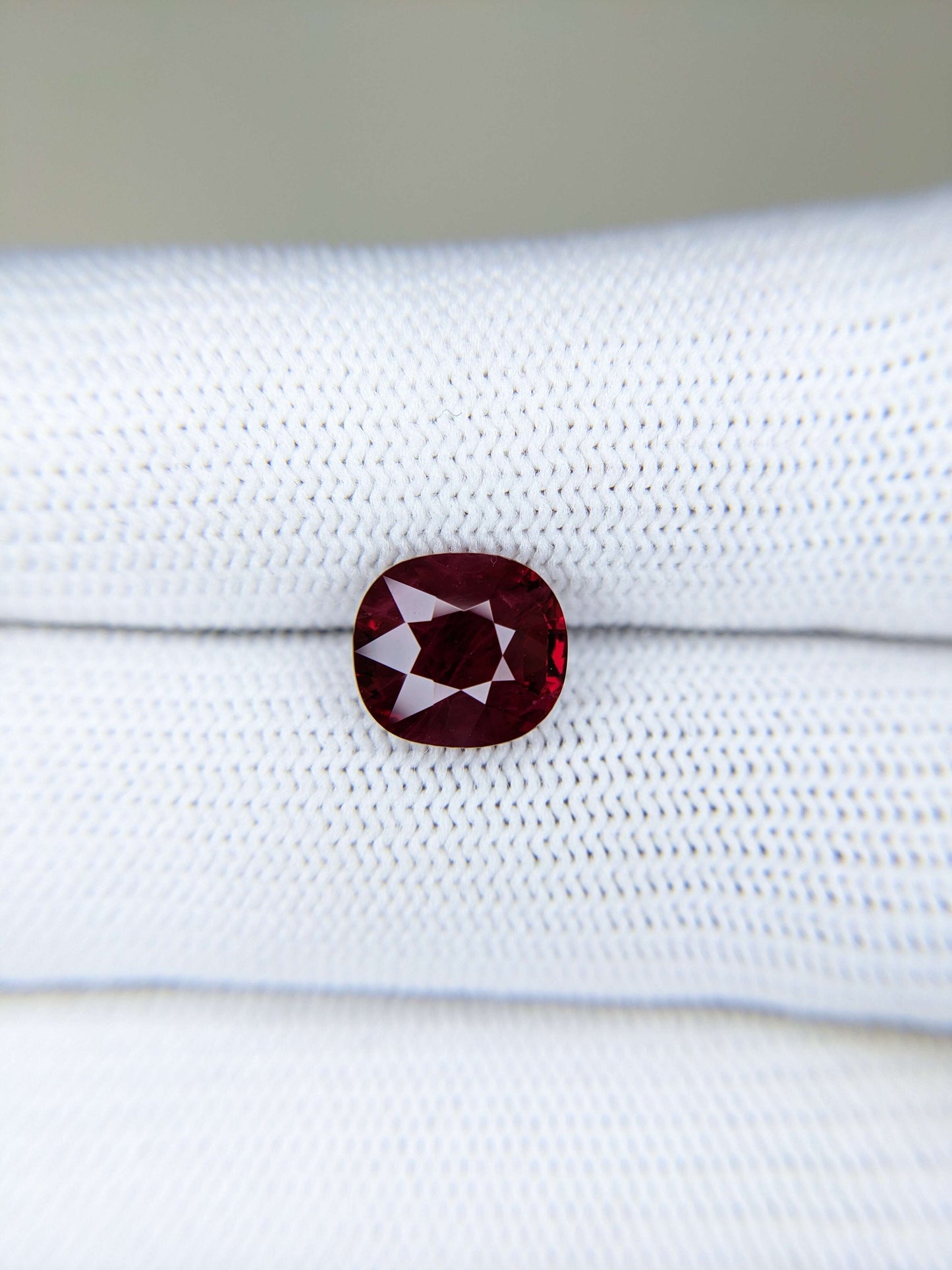 Red gemstone on a white gloves