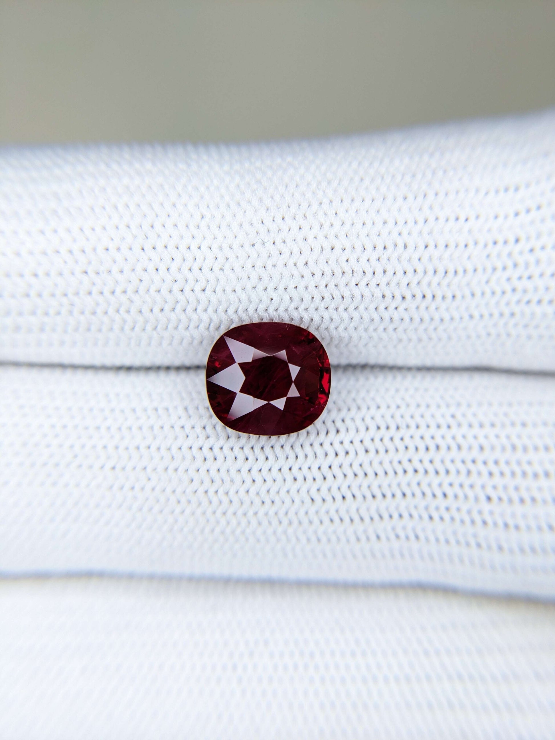 Red gemstone on a white gloves