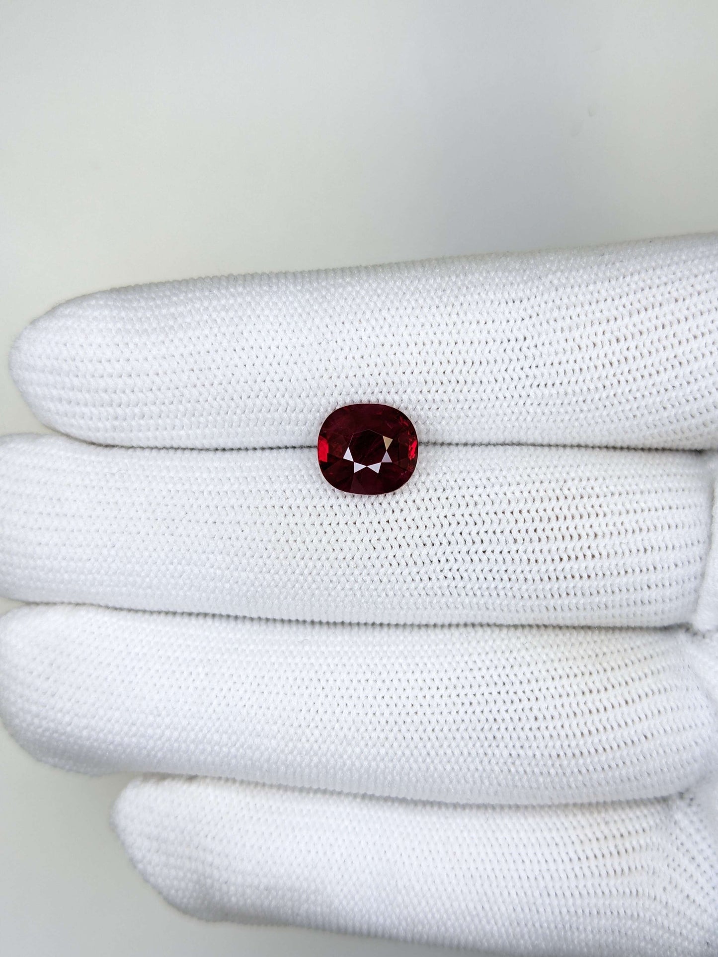 White glove with a red gemstone on a white background