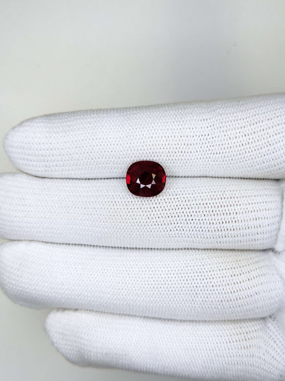 White glove with a red gemstone on a white background