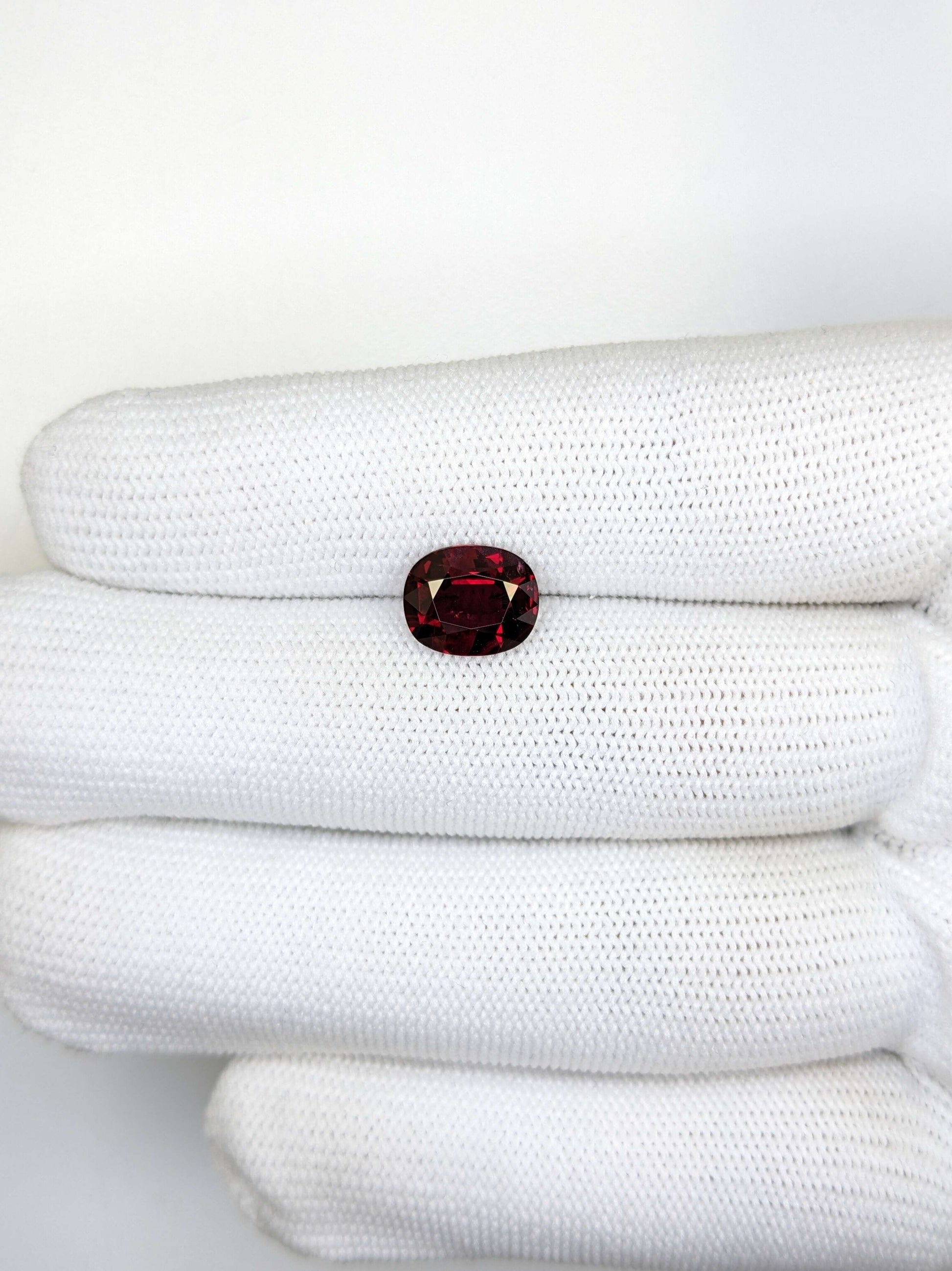 Red gemstone on a white textured surface
