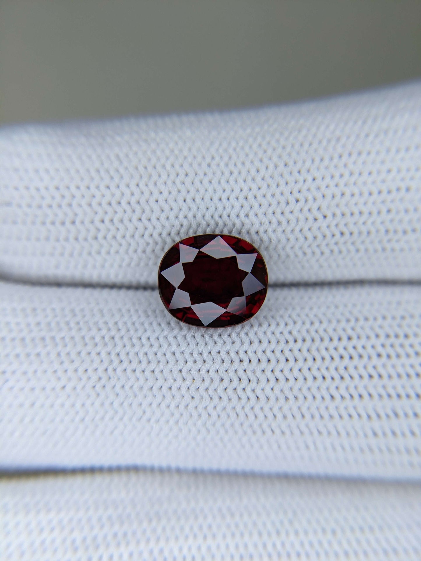 Red ruby gemstone on a white fabric background