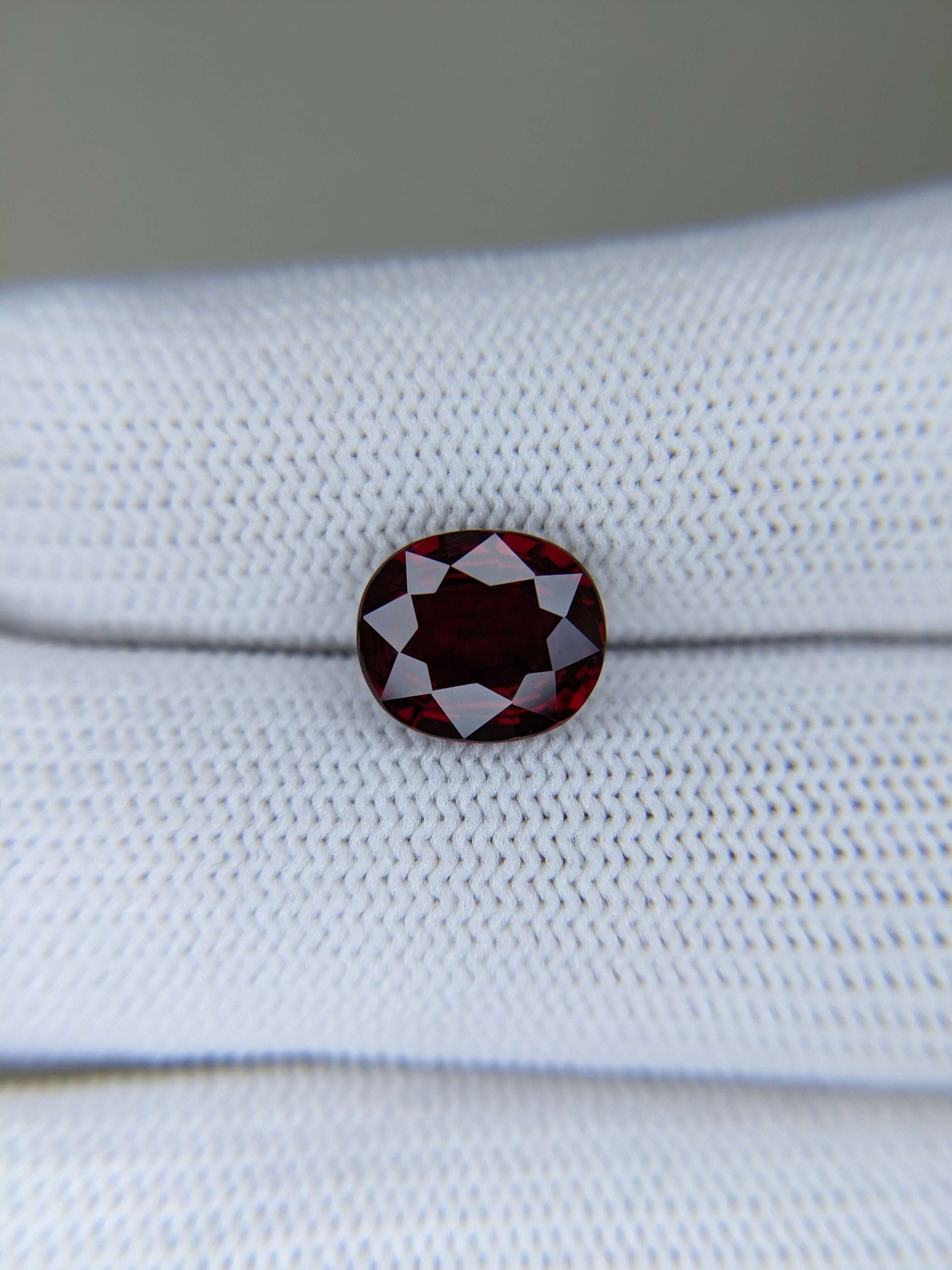 Red ruby gemstone on a white fabric background