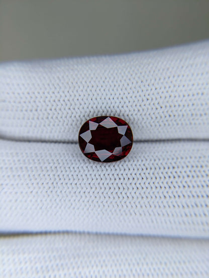 Red ruby gemstone on a white fabric background