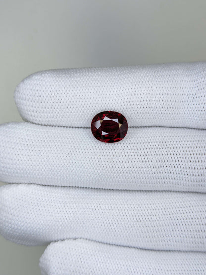 Red ruby gemstone on a white cloth with a gray background