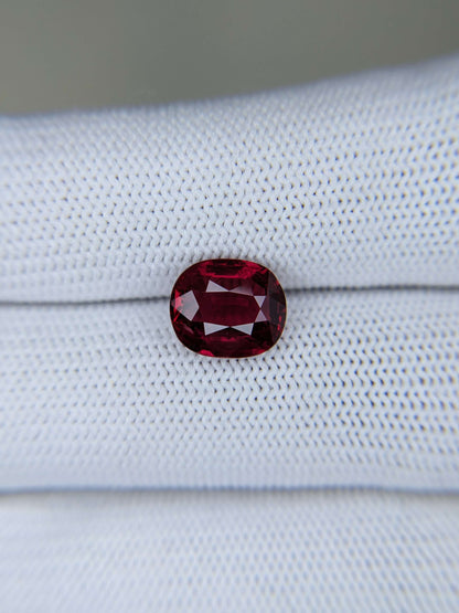 Red gemstone on a light gray fabric background