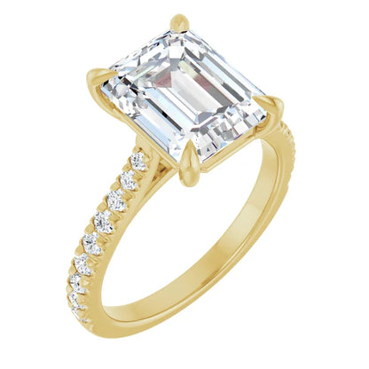 Gold ring with an emerald cut diamond and smaller diamonds on a white background