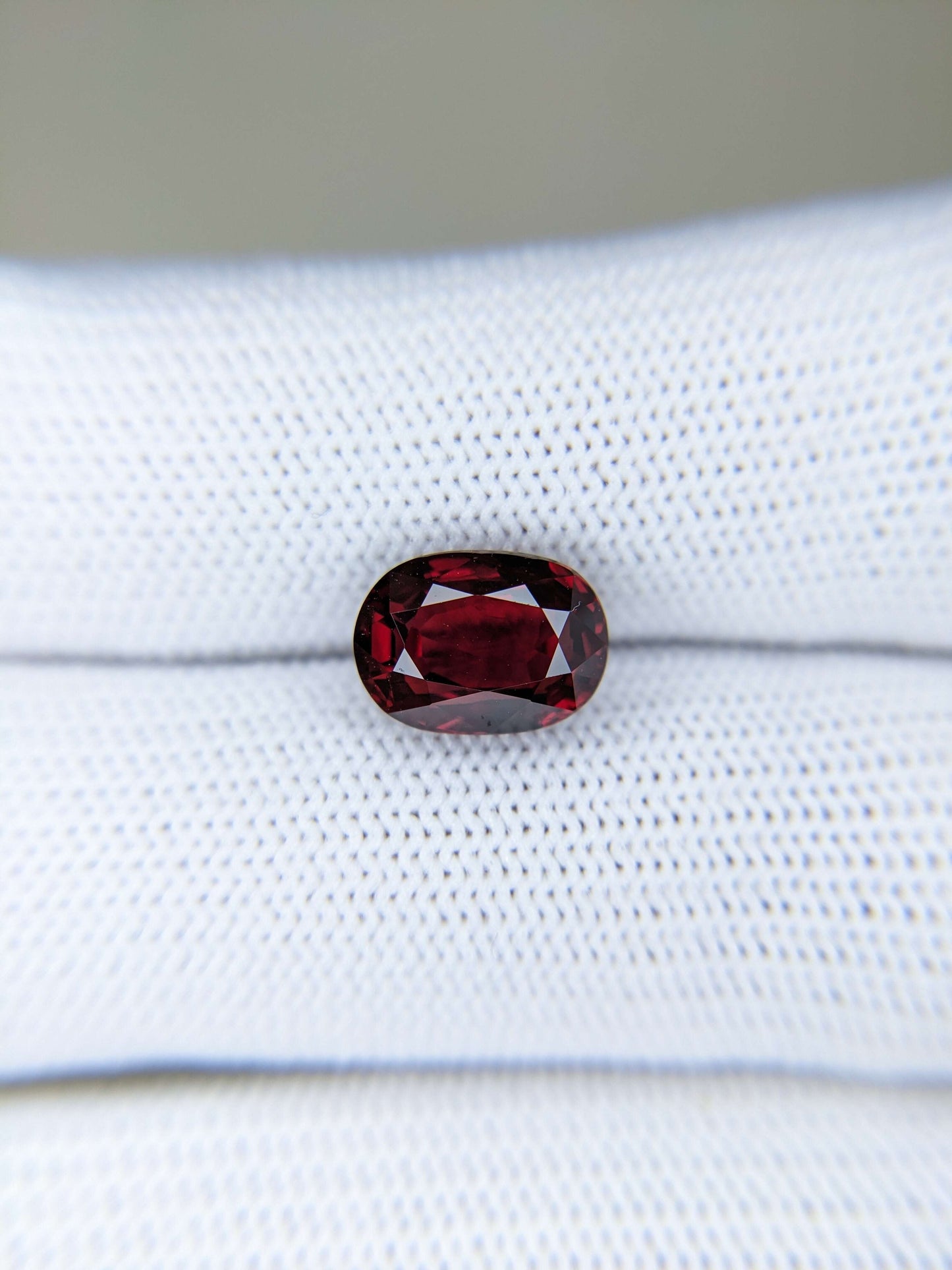 Red ruby gemstone on a white fabric background